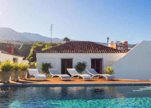 un grupo de sillas sentadas junto a una piscina en Casa Viña: a spectacular away from it all holiday en La Orotava