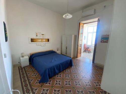 1 dormitorio con 1 cama azul en una habitación en Casa Rita in Piazza Marina en Isquia