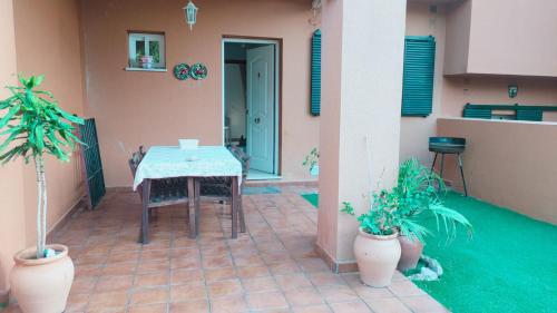 patio ze stołem i 2 doniczkami w obiekcie Casa adosada 3 habitaciones con piscina comunitaria w mieście Medina Sidonia