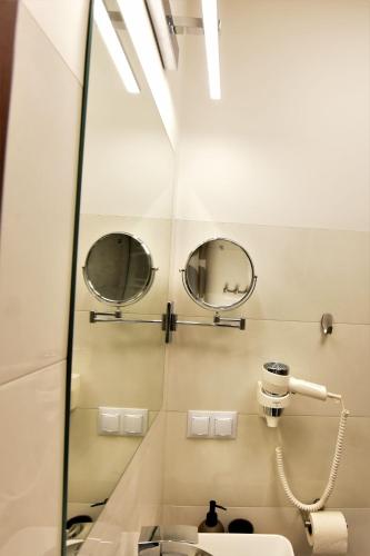 a bathroom with two mirrors and a sink at Pensjonat Zuzanna in Hajnówka