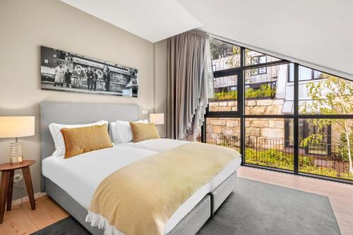 a bedroom with a large bed and a large window at 108MM House in Porto