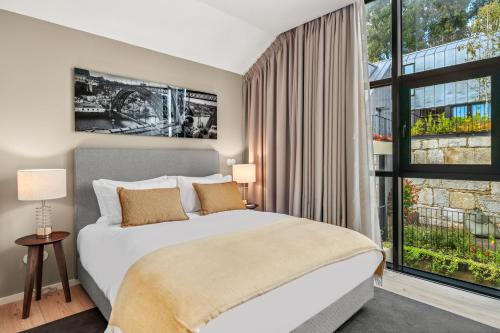 a bedroom with a bed and a large window at 108MM House in Porto