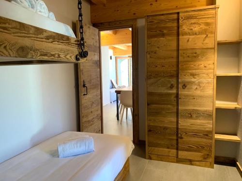 Schlafzimmer mit einem Bett und einem Schrank mit Holzwänden in der Unterkunft Chalet Del Sole in Monfol