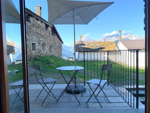 a table and chairs and an umbrella on a balcony at Chalet Del Sole in Monfol