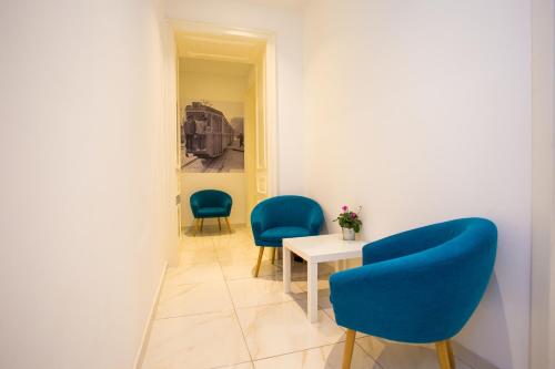 a waiting room with two blue chairs and a table at Apartments DOLAC Zagreb in Zagreb