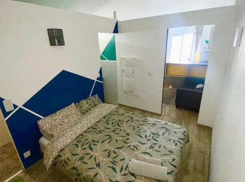 Location T1 Bis (RdC) / Emplacement Ideal في لو بوزين: غرفة نوم بسرير وجدار ازرق