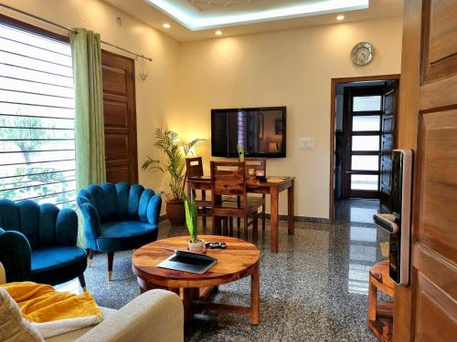 a living room with a couch and a table at Peaceful Home2 Stay by Six Lane in Sohāna