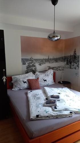 Una cama con sábanas blancas y almohadas. en Harrachovský apartmán, en Harrachov