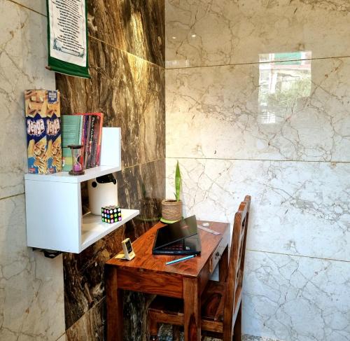 a desk with a laptop computer on a wooden table at Peaceful Home2 Stay by Six Lane in Sohāna