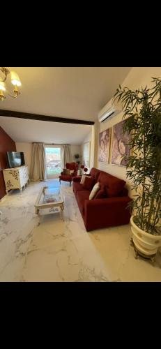 a living room with a red couch and a potted plant at El Comercio in Villarejo del Valle