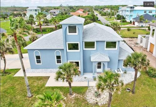 una vista aérea de una casa azul con palmeras en Luxury Ocean Blue beach house- 3 bed room Dog friendly en Palm Coast