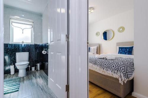 Un baño con una cama y un inodoro en una habitación. en Liverpool 4 Bed! Sleeps 9! Groups and Contractors! FREE OFF STREET PARKING! 3 Toilets! FREE WIFI!, en West Derby