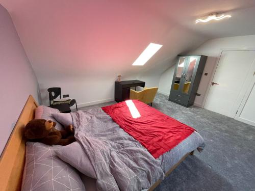 a bedroom with a teddy bear laying on a bed at Modern 4 Bedroom Stylish Villa with out-door Hot Tub in Quinton