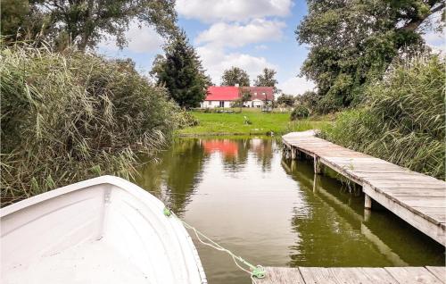 a boat tied to a wooden dock on a river at Nice Apartment In Wolin With Wifi in Wolin