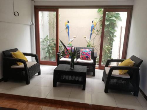 a living room with two chairs and a table with a vase at Tucuma Casa Hotel in Leticia