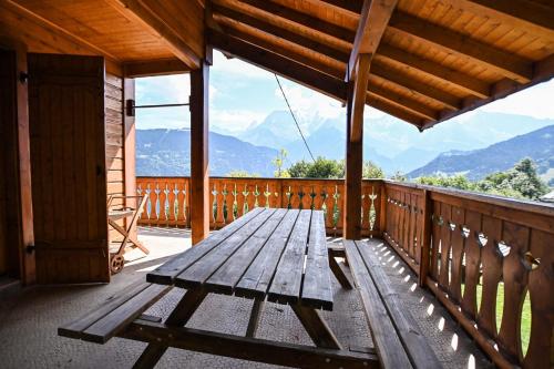 un banc en bois assis sur le pont d'une cabine dans l'établissement Chalet paisible de 170m avec jolie TERRASSE !, à Saint-Gervais-les-Bains