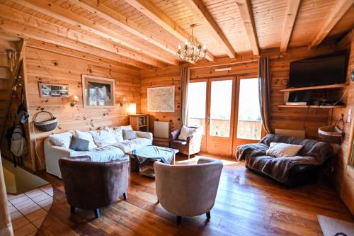- un salon avec des canapés et une télévision dans une cabane en rondins dans l'établissement Chalet paisible de 170m avec jolie TERRASSE !, à Saint-Gervais-les-Bains