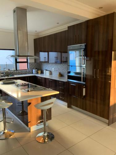 a kitchen with wooden cabinets and a large kitchen island at Almina villa in Windhoek