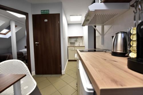 a kitchen with a wooden counter top in a room at Pensjonat Zuzanna in Hajnówka
