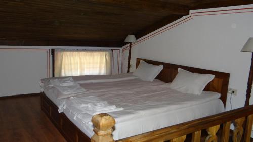a bedroom with a large bed with white sheets at Недкова къща in Koprivshtitsa