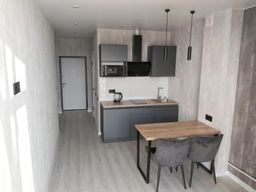 a kitchen with a wooden table and a dining room at Люкс Апартаменты Gray Pearl на Подолье in Vinnytsya