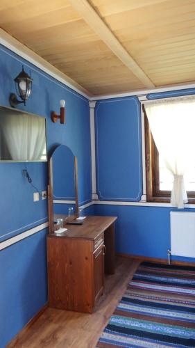 a blue bathroom with a sink and a mirror at Недкова къща in Koprivshtitsa