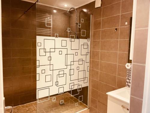 une douche avec une porte vitrée dans une salle de bain dans l'établissement Appartement 2 chambres avec parking privé gratuit, à Dijon