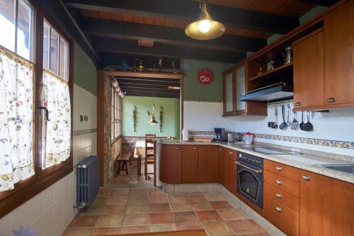 uma cozinha com armários de madeira e um forno com placa de fogão em Casa Gelito em Espinareda de Vega
