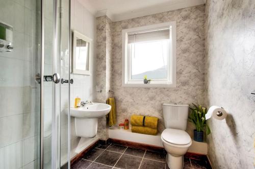 ein Bad mit einem WC, einem Waschbecken und einer Dusche in der Unterkunft Braemor 4 bedroom villa, all en-suite in Arrochar