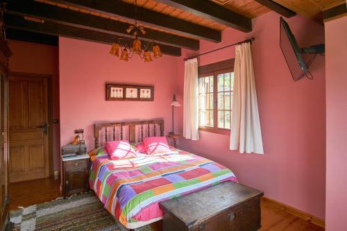 a bedroom with pink walls and a bed with pink pillows at Casa Gelito in Espinareda de Vega