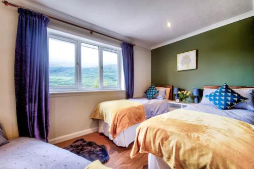 a bedroom with two beds and a window at Braemor 4 bedroom villa, all en-suite in Arrochar