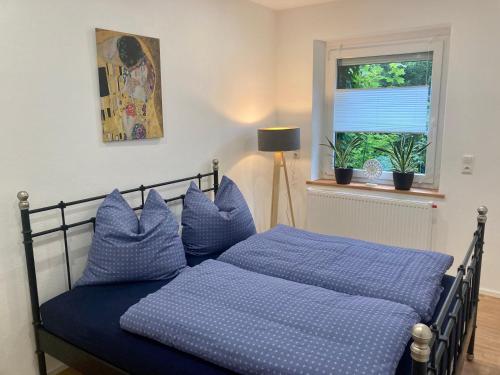 a blue bed with blue pillows in a bedroom at Schiller Apartment in Münchberg