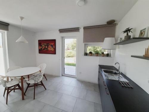 a kitchen with a table and a table and chairs at Green Bee Apartment in Lesce