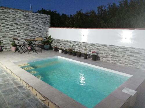 een zwembad in een patio met een tafel en stoelen bij La magia del sur 2 in Cádiz