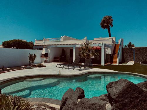 uma piscina em frente a uma casa em Villa Jardín em Playa Blanca