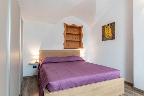 een kleine slaapkamer met een paars bed in een kamer bij Residenza Glicine in Pergine Valsugana