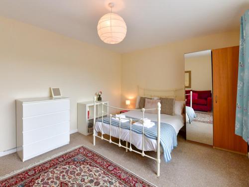 a bedroom with a bed and a mirror at Pass the Keys Spacious 4 Bedroom home with Parking Garden in Barry