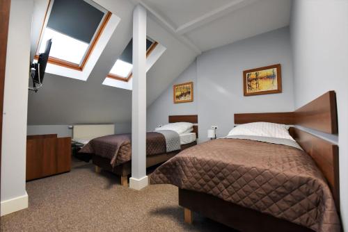 sypialnia z 2 łóżkami i telewizorem z płaskim ekranem w obiekcie Pensjonat Zuzanna w Hajnówce