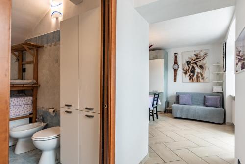 een badkamer met een toilet en een woonkamer bij Residenza Glicine in Pergine Valsugana