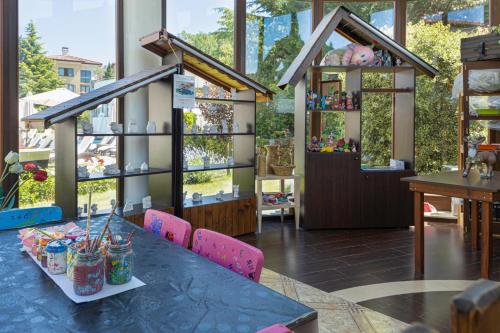 a room with a table and chairs and windows at Pirin Park Hotel in Sandanski