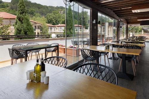 a restaurant with tables and chairs on a balcony at Pirin Park Hotel in Sandanski