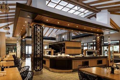 a restaurant with tables and chairs and a counter at Pirin Park Hotel in Sandanski