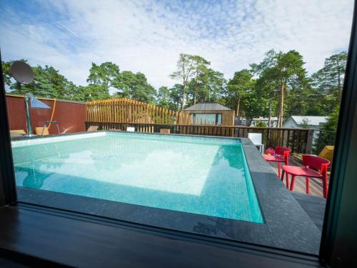 a swimming pool on a patio with a table and chairs at Villa Lettonia in Jūrmala
