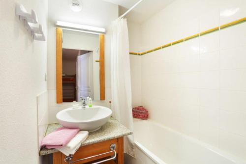 a bathroom with a sink and a tub and a mirror at T3 - 6 PERS - PIEDS DES PISTES + PISCINE BALCON in Ax-les-Thermes