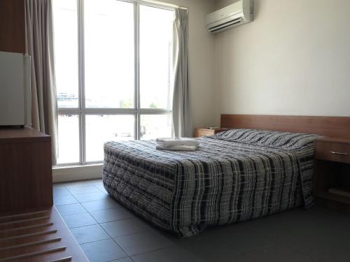 1 dormitorio con cama y ventana grande en Upper Ross Hotel, en Townsville