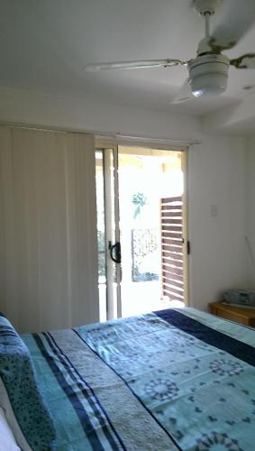 a bedroom with a bed with a blue comforter at Tropical Coast Retreat - Pet Friendly - Adult only in Kingscliff