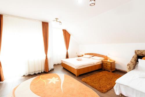 een slaapkamer met 2 bedden en een groot raam bij Casa VLC Punct Gastronomic Local Bilbor in Rocoteaş