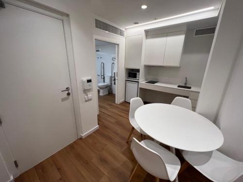 a white kitchen with a white table and chairs at Old Town Flats Casa del Bisbe in Valencia