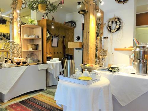 eine Küche mit 2 Tischen und einer Theke mit einer Theke in der Unterkunft Pension Zur Fährbrücke in Stralsund