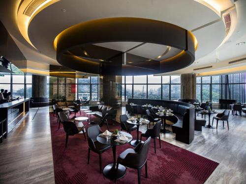 a restaurant with tables and chairs and a large ceiling at Shenzhen O Hotel in Shenzhen